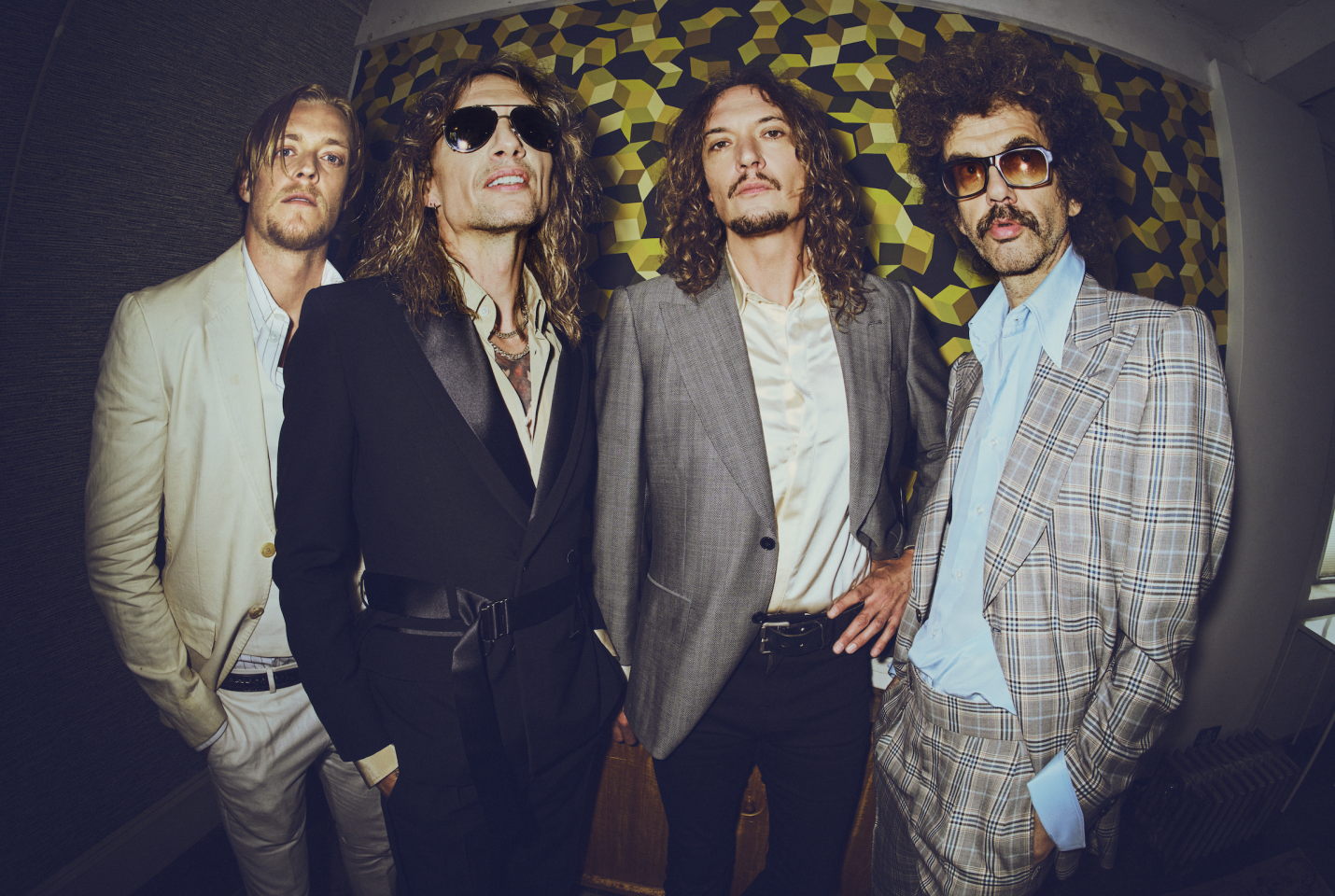 The Darkness in suits facing camera